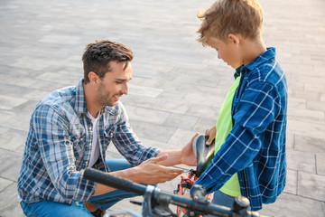 Wall Mural - Father and his son repairing bicycle outdoors