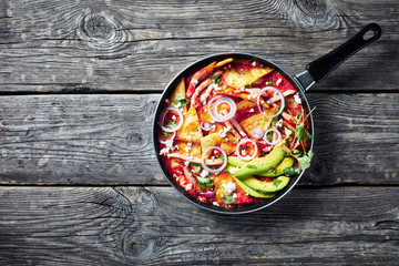 chilaquiles with ham, cheese, avocado, top view