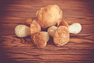      Six boletus lie on brown wooden background 