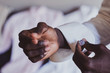 © Fxquadro - Closeup photo shoot of african american man in white shirt with diamond cufflink in hand.