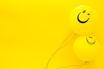 happiness emotion. yellow balloon with smile on yellow background top view space for text