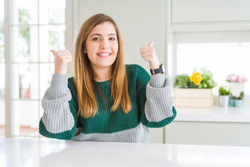 Poster - Young beautiful plus size woman wearing casual striped sweater success sign doing positive gesture with hand, thumbs up smiling and happy. Cheerful expression and winner gesture.