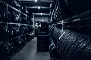 Dark storage full or big variety of new tyres at busy warehouse.