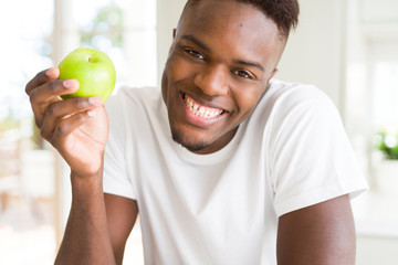 Sticker - Young african american man eating a healthy green apple