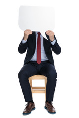 Wall Mural - young businessman hiding behind speech bubble