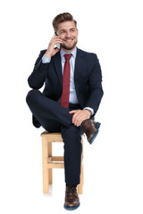 Wall Mural - elegant young businessman talking on the phone in studio