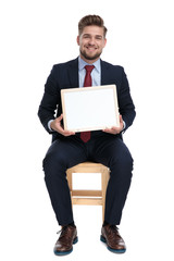 Wall Mural - happy young businessman holding white board in studio