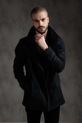 attractive young fashion model wearing black longcoat