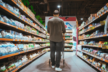 man do grocery shopping at supermarket