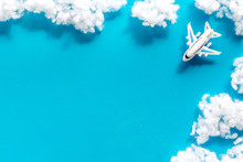 Fly By Plane Concept. Airplane Model And Clouds On Blue Background Top View Frame Space For Text
