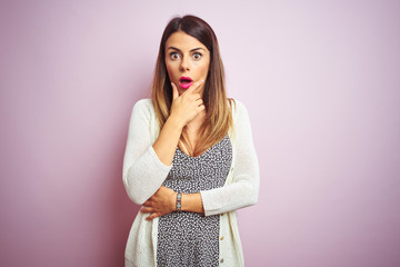 Poster - Young beautiful woman standing over pink isolated background Looking fascinated with disbelief, surprise and amazed expression with hands on chin