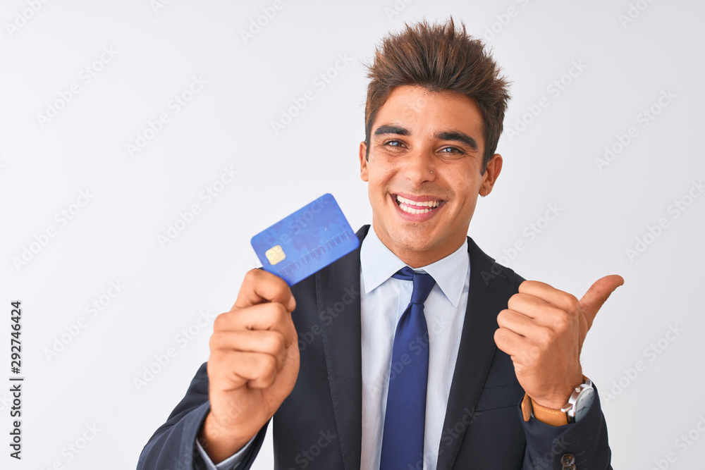 Young handsome businessman wearing suit holding credit card over ...