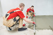 © Kadmy - Floor cement work. Plasterer smoothing floor surface with screeder