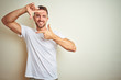 © Krakenimages.com - Young handsome man wearing casual white t-shirt over isolated background smiling making frame with hands and fingers with happy face. Creativity and photography concept.