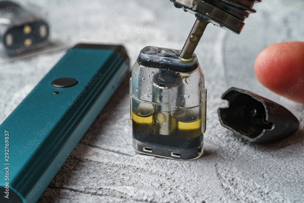 vape pen refill liquid Refill with e-juice or liquid with salt nicotine of replacement cartridge  for vape pod or new vape pen device Stock Photo