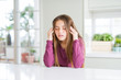 © Krakenimages.com - Beautiful young girl kid on white table with hand on head for pain in head because stress. Suffering migraine.