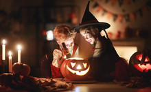 Happy Children In Costumes Of Witch And Vampire In A Dark House In Halloween.