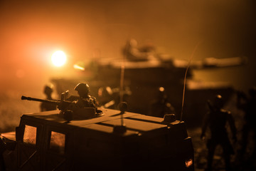 Military patrol car on sunset background. Army war concept. Silhouette of armored vehicle with soldiers ready to attack. Artwork decoration. Selective focus