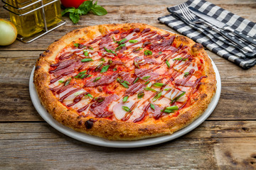 Wall Mural - Pizza with meat and barbecue sauce on wooden table