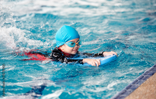 Plakaty pływanie  jedna-dziewczyna-w-kostiumie-kapielowym-uzywa-podkladki-piankowej-aby-cwiczyc-plywanie-w-basenie-z