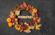 autumn decor wreath, October time. harvest season background. acorns, leaves, nuts and cones in wreath on dark template. autumn holiday, fall, thanksgiving, halloween concept. copy space