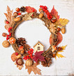 Festive autumn Thanksgiving wreath with pumpkin, fall leaves, red berries, acorns on light background. autumn holiday, fall, thanksgiving, halloween concept. Flat lay, top view, copy space