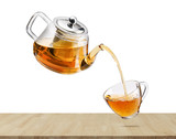 Fototapeta Mapy - Jug pouring hot tea into glass cup with flying whirl green tea leaves in the air, Healthy products by organic natural ingredients concept, Empty space in studio shot isolated on white background
