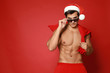© New Africa - Sexy shirtless Santa Claus on red background, space for text