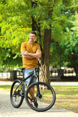 Wall Mural - Handsome man with modern bicycle in park