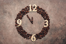 Abstract Clock Made Of Roasted Coffee Beans On A Dark Brown Rustic Background. New Year Concept. Five Minutes To Twelve.