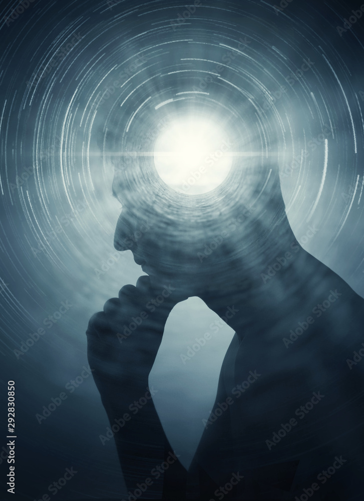 A silhouette of a man with rays of light emanating from the brain as a symbol of the power of thinking. Concept on the topic of psychiatry, psychology, religion, science, spiritual growth. - obrazy, fototapety, plakaty 