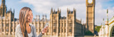 Fototapeta Londyn - Phone london Asian young woman using cellphone texting on online app on Europe travel city lifestyle banner panorama background.