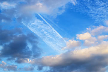 Wall Mural - beautiful white and gray fluffy clouds high in a blue sky. skyscape with wide airplane trace on a da