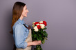 © deagreez - Profile photo of sale manager lady holding big bunch of roses delivering it to clients house wear jeans shirt covered by apron isolated grey background
