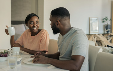 Wall Mural - Smiling young African American couple enjoying breakfast together at home