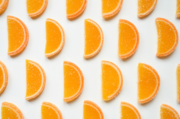 citrus jelly slices in sugar. marmalade slices of oranges and laid rows on a white background. top view