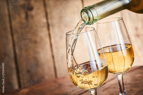 Fotografía Dispensing golden white wine into two wineglasses