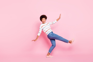 Wall Mural - Full body profile photo of pretty dark skin lady at dancing class learning new modern moves wear striped pullover and jeans isolated pastel pink color background