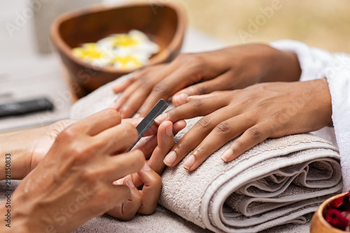 Valokuva Beautician file nails to a black hand