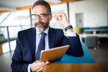 Wall Mural - Shot of thinking financial advisor businessman working in office.