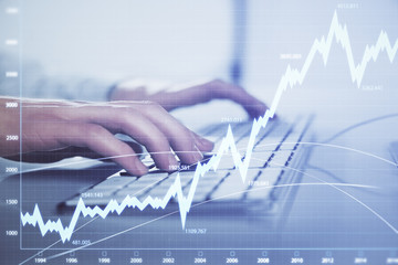 Forex graph with businessman working on computer in office on background. Concept of hardworking. Closeup. Multi exposure.