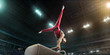 Male athlete doing a complicated exciting trick on a Pommel horse in a professional gym. Man perform stunt in bright sports clothes