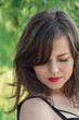 © Nataliia - Young girl with closed eyes and long eyelashes, look down. Portrait of young beautiful woman with bare shoulders, on green background, summer nature. Beauty portrait