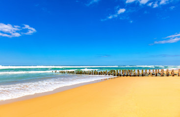 View of wooden pillars and stones on the beach of Seignosse, Landes, France