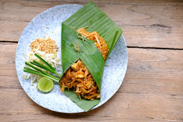 Wall Mural - pad thai noodle with shrimp on wood table