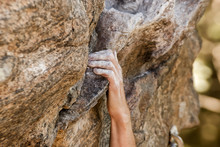 Closeup View Of Rock Climber's Hand Gripping Hold On Natural Cliff