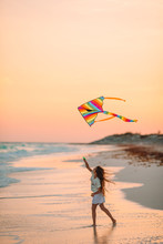 Little Running Girl With Flying Kite On Tropical Beach. Kid Play On Ocean Shore.