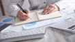 © andranik123 - Girl writing on notepad in office desk.