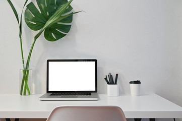 Mockup laptop computer, coffee, pencil and plant decoration with workspace computer.