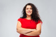 © Syda Productions - people and confidence concept - happy woman in red dress with crossed arms over grey background